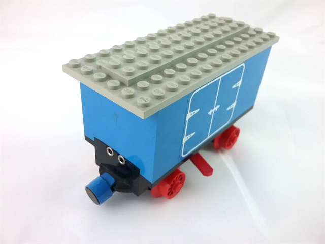 Lego Train Battery Box Car with Two Contact Holes, Red Switch Lever, Blue and Red Magnets, Red Wheels, and Light Gray Roof with Hinged Doors Pattern on Both Sides (Stickers) - Set 7720