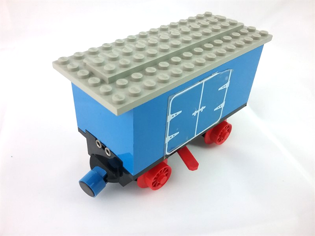 Lego Train Battery Box Car with Three Contact Holes, Red Switch Lever, Blue and Red Magnets, Red Wheels, and Light Gray Roof with Hinged Doors Pattern on Both Sides (Stickers) - Set 7720